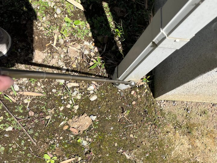 打診棒で竪樋を叩く様子