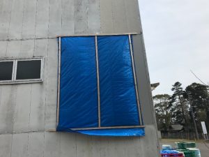 強風の影響で外壁材が一部剥がれた倉庫(養生した箇所)