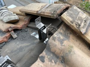 棟瓦の補強金物を設置する作業工程