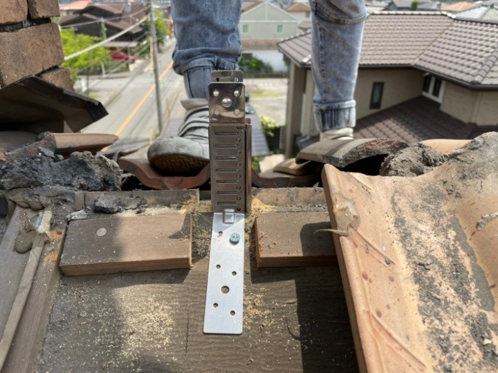 棟瓦の補強金物を設置する風景