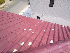 棟瓦の下地（漆喰）が崩れて屋根に転がっている状況