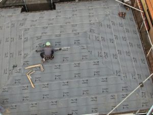 防水紙（アスファルトルーフィング）を敷設している作業工程