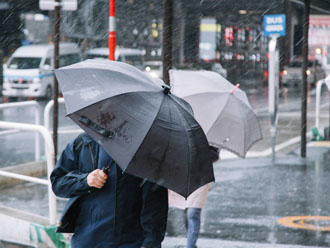 台風時に通勤する人々